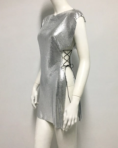 Détail de robe à paillettes argentées avec fente latérale et lacets noirs croisés