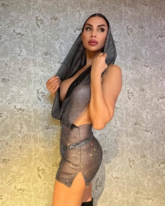 Détail de la robe licou en résille noire avec strass brillants et découpe latérale audacieuse