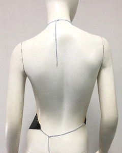 Détail du haut dos nu à paillettes montrant le design en maille métallique noir et argent