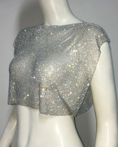 Detailed close-up of sparkling silver rhinestone mesh on a cropped metallic party top
