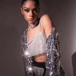 Détail du haut en strass argenté et de la veste à paillettes pour un look de fête