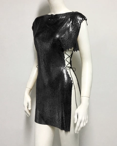 Détail d'une robe en maille métallique noire avec laçage latéral et sequins brillants
