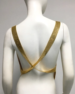 Detail of gold metal mesh sequins on a backless crisscross strap top for parties