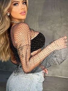 Top sexy in rete nera con strass scintillanti e jeans in denim a vita alta