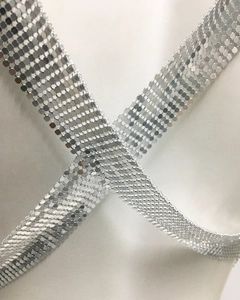 Close-up of shiny silver metal sequin mesh fabric with hexagonal honeycomb chain link