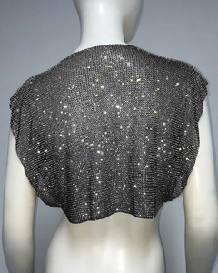 Detail of metal mesh sequin vest with colorful rhinestones on a white mannequin