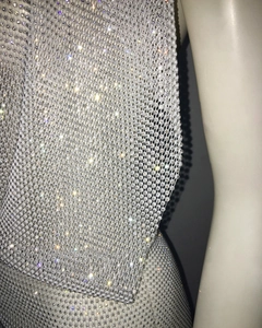 Gros plan de strass argentés étincelants sur le tissu en maille d'une robe de soirée