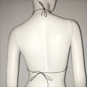 Vue détaillée du dos d'un haut en filet noir avec lacets en strass sur un mannequin féminin