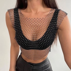 Détail de la veste en maille noire avec strass argentés brillants et tissu transparent