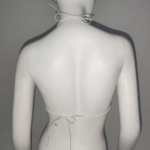 Détail du haut en résille blanc avec strass et bretelles croisées nouées dans le dos