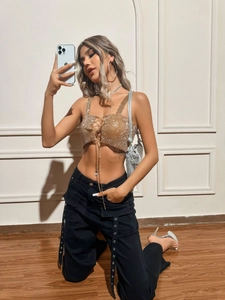 Sparkly gold sequin halter top with criss-cross chains paired with black cargo pants