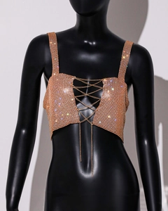 Detailed view of rose gold rhinestone crop top with criss-cross metal chains on a model