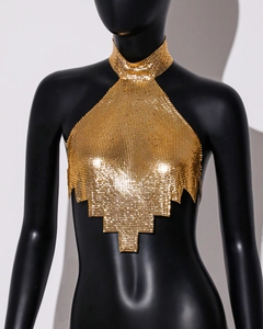 Detail of gold metal mesh halter top featuring sequin chainmail and asymmetric hem