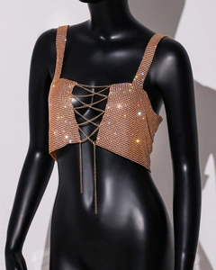 Detail of luxury gold rhinestone crop top featuring crisscross metallic chains