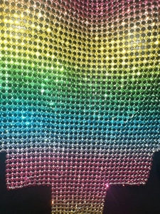 Macro shot of colorful rhinestone mesh fabric with vibrant rainbow gradient texture