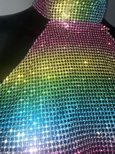Detailed close-up of rainbow gradient rhinestone mesh top with metal chain links