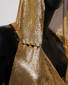 Detailed view of shimmering gold metallic chainmail texture and hooded design on a party top
