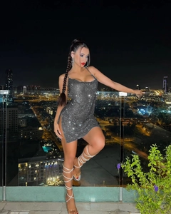 Close-up of sparkling silver rhinestone mini dress with side slit and draped neckline