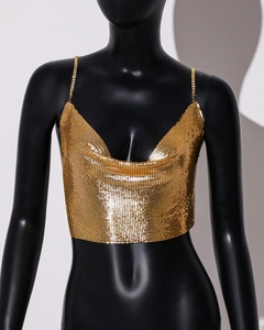 Detailed view of shimmering gold sequin mesh material and slim chain straps on sexy crop top
