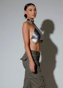Detail of silver metallic sequin halter top featuring chainmail texture and backless design