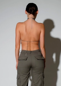 Back view of metallic sequin halter top with chain straps and green cargo pants