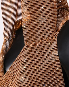 Gros plan d'un gilet en maille métallique dorée ambrée avec strass scintillants et drapé