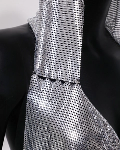 Detailed macro view of shimmering silver sequin mesh texture on a metallic party top