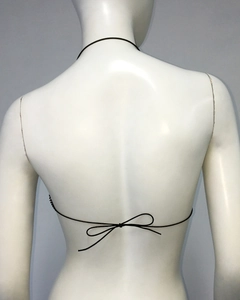 Detail of black fishnet camisole featuring back lace-up straps and a bow tie design