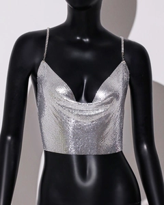 Macro shot of silver metal sequins and delicate chain straps on a sexy V-neck party top