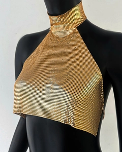 Gros plan sur les paillettes métalliques dorées et la maille du haut dos nu chic