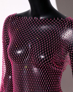 Detail of pink mesh rhinestone dress with sparkling crystals on black mannequin