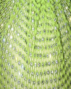 Macro shot of neon green mesh headpiece featuring high-density sparkling rhinestones