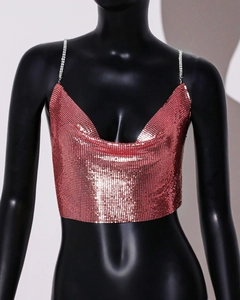 Detailed macro view of rose gold metal sequins and sparkling rhinestone straps on crop top