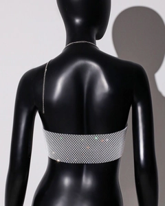 Detailed view of shimmering silver rhinestone mesh vest on a black mannequin back