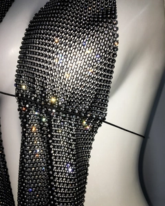 Détail macro d'un haut licou sexy en maille noire avec strass brillants pour la fête