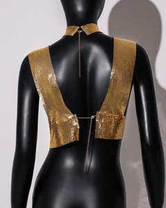 Detail of gold metal mesh sequins and adjustable back chain on a backless party top