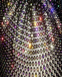 Macro shot of shimmering AB rhinestones on a black mesh stretch cycling mask texture