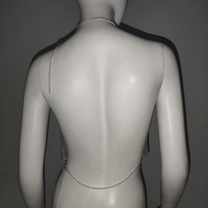 Detailed back view of silver metallic sequin backless top with waist chain on mannequin