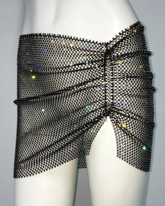 Detail of black rhinestone fishnet mini skirt with asymmetrical hem and sparkling crystals