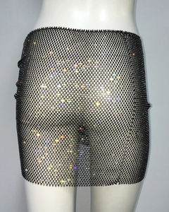 Detail of black rhinestone mesh mini skirt showing sparkling crystals on fishnet fabric