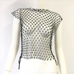 Detail of black rhinestone mesh top featuring floral chain links and side fringe tassels