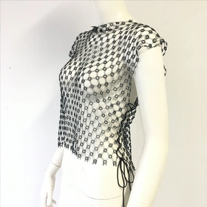 Detailed view of black fishnet vest featuring floral hollow patterns and side tie-up cords