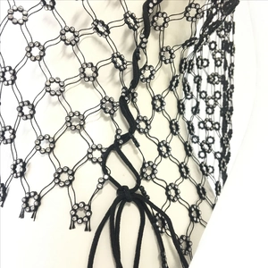 Close-up of black mesh top with sparkling rhinestones and lace-up front detail