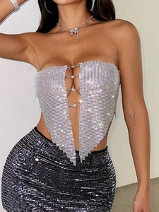 Détail macro du haut bustier argenté à strass avec chaînes en métal et cristaux brillants