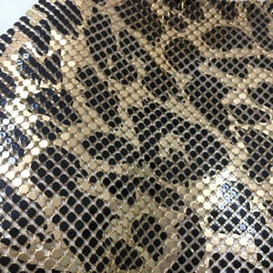 Macro view of leopard print metallic mesh fabric with gold and black sequins