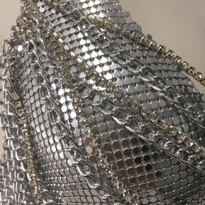Macro shot of silver metal mesh texture with luxury rhinestone chains and metallic details
