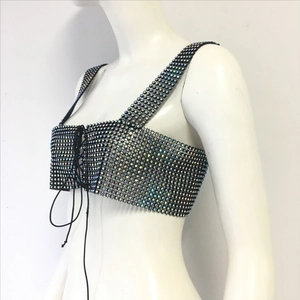 Détail du haut en maille noire avec strass brillants et laçage ajustable sur le devant