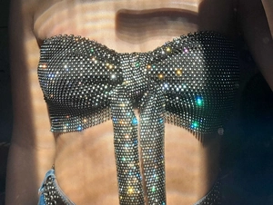 Close-up of sparkling rhinestone bow corset top with shimmering mesh and colorful crystals