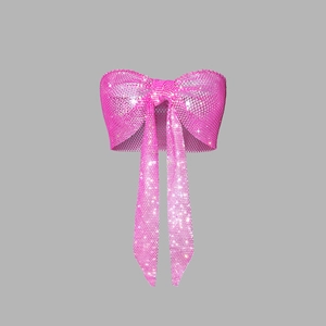Detail view of sparkly pink rhinestone bow crop top with long dangling fringe tassels