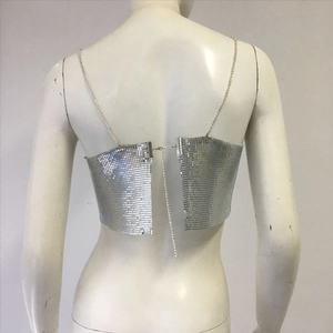 Detail of silver metallic sequin crop top featuring chain straps and an open back design